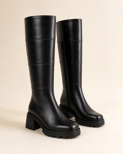 Women's black chunky knee-high boots, full silhouette.