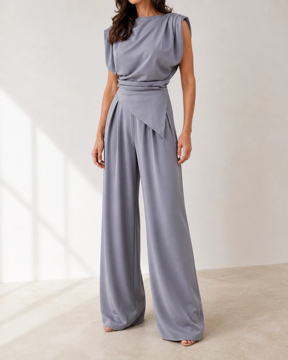 Women's dark grey asymmetric draped top and wide-leg trousers set, product-first view.